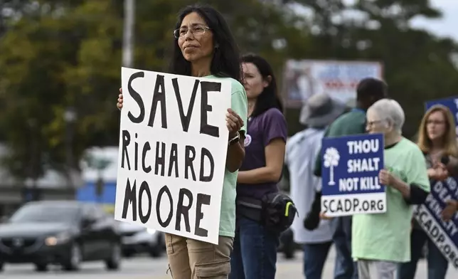 Protestors look on prior to the scheduled execution of Richard Moore, Friday, Nov. 1, 2024, outside of Broad River Correctional Institution in Columbia, S.C. (AP Photo/Matt Kelley)