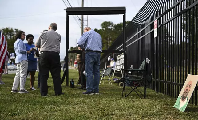 A photo of Richard Moore, right, is propped along a fence as protestors gather prior to Moore's scheduled execution, Friday, Nov. 1, 2024, outside of Broad River Correctional Institution in Columbia, S.C. (AP Photo/Matt Kelley)