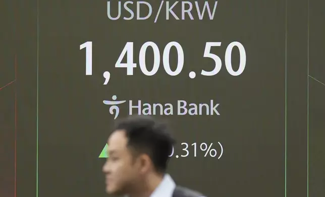 A currency trader walks by the screens showing the foreign exchange rate between U.S. dollar and South Korean won at a foreign exchange dealing room in Seoul, South Korea, Thursday, Nov. 7, 2024. (AP Photo/Lee Jin-man)