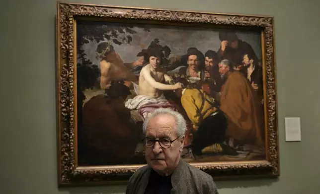 Novelist John Banville poses by Diego Velazquez's 'The Feast of Bacchus' at the Prado Museum in Madrid, Spain, Wednesday, Oct. 23, 2024. (AP Photo/Paul White)