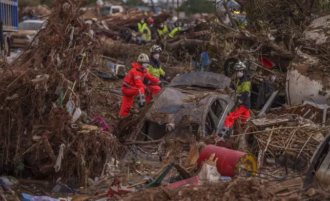 Emergency services remove cars in an area affected by floods in Catarroja, Spain, on Sunday, Nov. 3, 2024. (AP Photo/Manu Fernandez)