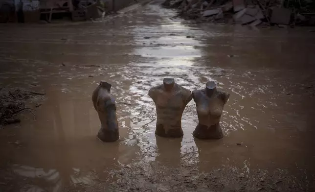 Mannequins are photographed partially buried in mud in an area affected by floods in Masanasa, Valencia, Spain, Wednesday, Nov. 6, 2024. (AP Photo/Emilio Morenatti)