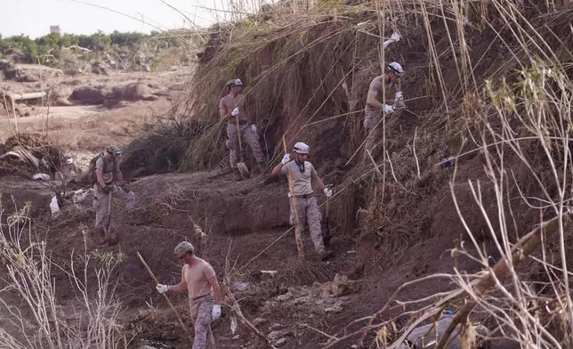 Soldiers from the Spanish Parachute Squadron (EZAPAC) look for bodies after floods in Barranco del Poyo, Spain, Tuesday, Nov. 5, 2024. (AP Photo/Alberto Saiz)