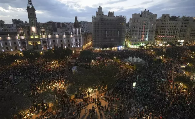 Thousands of demonstrators gather infant of the city council for a protest organized by social and civic groups, denouncing the handling of recent flooding under the slogan "Mazón, Resign," aimed at the president of the regional government Carlos Mazon, in Valencia, Spain, Saturday, Nov. 9, 2024. (AP Photo/Emilio Morenatti)