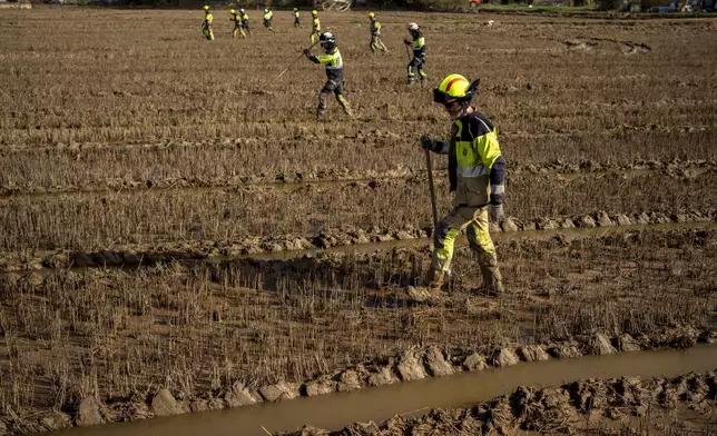 Members of the fire brigade search the area for bodies washed away by the floods in the outskirts of Valencia, Spain, Friday, Nov. 8, 2024. (AP Photo/Emilio Morenatti)