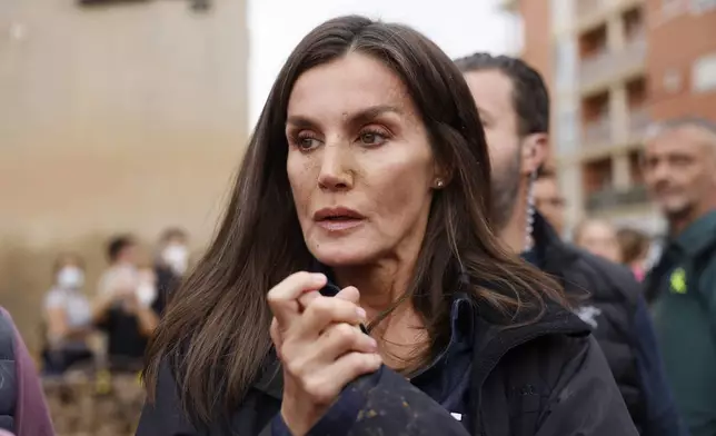 Spain's Queen Letizia speaks with people affected by the floods in Paiporta, near Valencia, Spain, Sunday Nov. 3, 2024. A crowd of angry survivors of Spain's floods have tossed mud and shouted insults at Spain's King Felipe VI and government officials when they made their first visit to one of the hardest hit towns. (Ana Escobar/EFE via AP)