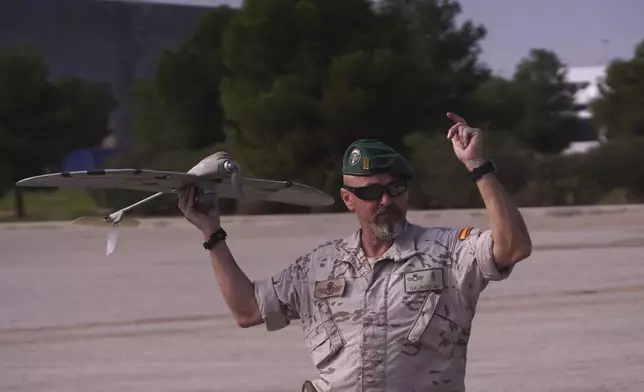 A soldier from the Spanish Parachute Squadron (EZAPAC) launches a drone in the search for bodies after floods in Barranco del Poyo on the outskirts of Valencia, Spain, Tuesday, Nov. 5, 2024. (AP Photo/Alberto Saiz)