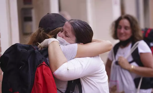 Two people hug each other after floods on the outskirts of Valencia, Spain, Monday, Nov. 4, 2024. (AP Photo/Alberto Saiz)