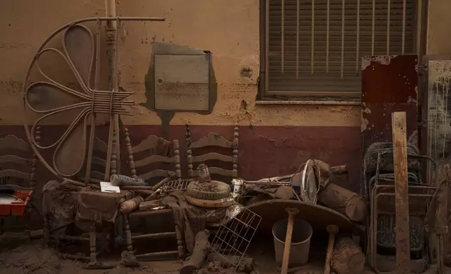 Items covered in mud are pictured in an area affected by floods, in Algemesi, Spain, Sunday, Nov. 3, 2024. (AP Photo/Manu Fernandez)