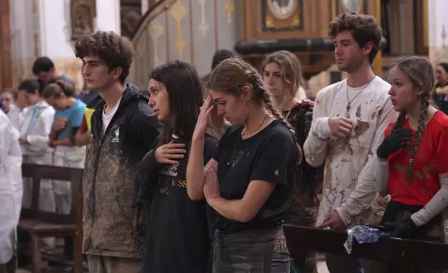 People attend a mass at the San Jorge church after floods in Paiporta, Spain, Thursday, Nov. 7, 2024. (AP Photo/Alberto Saiz)