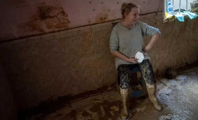 Dolores Merchan, 67, reacts in tears at her home, where she has lived all her life with her husband and three children, and which has been severely affected by the floods in Masanasa, Valencia, Spain, Thursday, Nov. 7, 2024. (AP Photo/Emilio Morenatti)