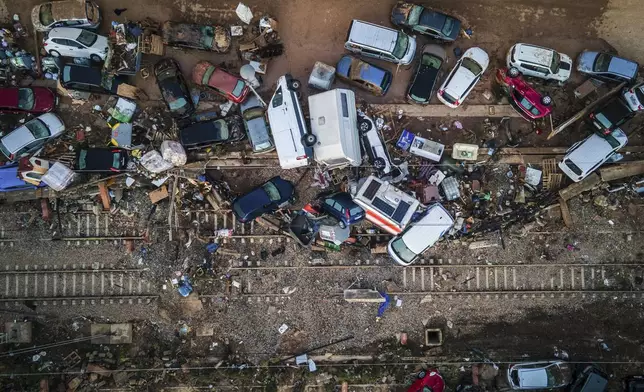 Vehicles pile up on the train tracks in the aftermath of flooding caused by late Tuesday and early Wednesday storm that left hundreds dead or missing in Alfafar, Valencia region, Spain, Saturday, Nov. 2, 2024.(AP Photo/Angel Garcia)