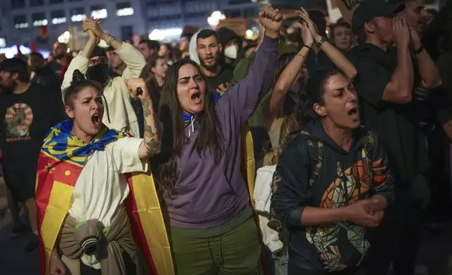 Demonstrators shout slogans as they gather for a protest organized by social and civic groups, denouncing the handling of recent flooding under the slogan "Mazón, Resign," aimed at the president of the regional government Carlos Mazon, in Valencia, Spain, Saturday, Nov. 9, 2024. (AP Photo/Emilio Morenatti)