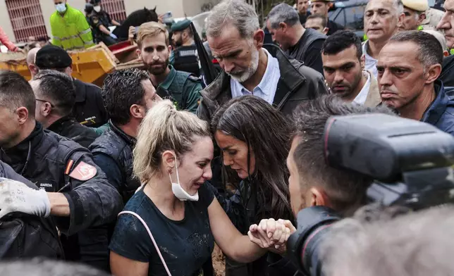 Spain's Queen Letizia next to Spain's King Felipe VI speaks with a woman affected by the floods in Paiporta, near Valencia, Spain, Sunday Nov. 3, 2024. (Carlos Luján/Europa Press via AP) **SPAIN OUT**