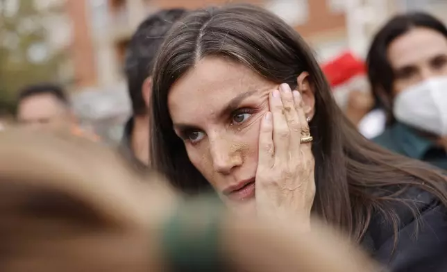 Spain's Queen Letizia speaks with people affected by the floods in Paiporta, near Valencia, Spain, Sunday Nov. 3, 2024. A crowd of angry survivors of Spain's floods have tossed mud and shouted insults at Spain's King Felipe VI and government officials when they made their first visit to one of the hardest hit towns. (Ana Escobar/EFE via AP)