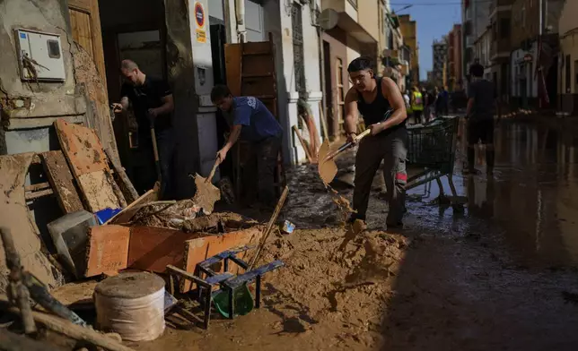 People clean their houses affected by floods in Valencia, Spain, Thursday, Oct. 31, 2024. (AP Photo/Manu Fernandez)