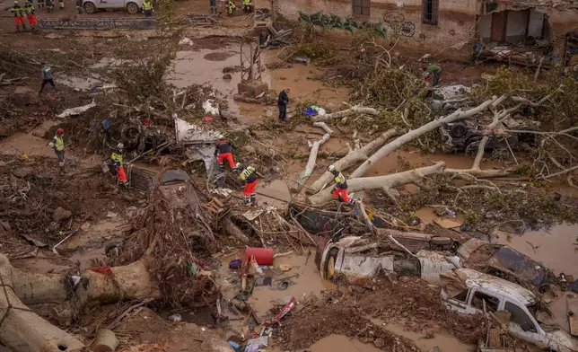 Emergency services remove cars in an area affected by floods in Catarroja, Spain, on Sunday, Nov. 3, 2024. (AP Photo/Manu Fernandez)