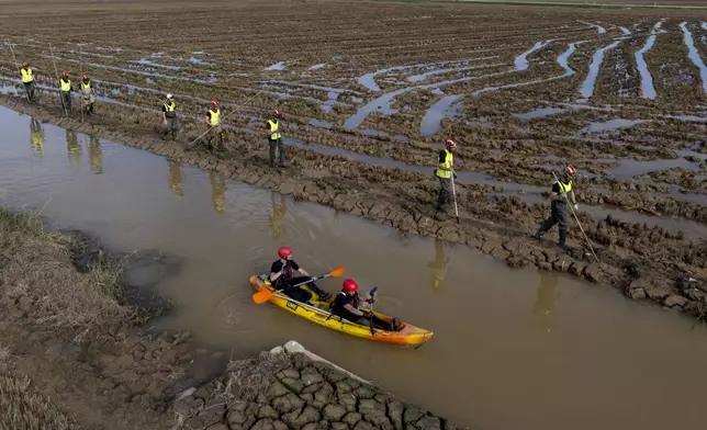 Members of the V battalion of the military emergency unit, UME, search the area for bodies washed away by the floods in the outskirts of Valencia, Spain, Friday, Nov. 8, 2024. (AP Photo/Emilio Morenatti)