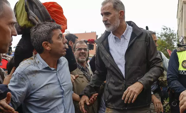 Spain's King Felipe VI, right, reacts next to the President of the Valencian government Carlos Mazon in Paiporta, near Valencia, Spain, Sunday Nov. 3, 2024 after a crowd of angry survivors of Spain's floods have tossed mud and shouted insults at the King and government officials when they made their first visit to one of the hardest hit towns. (Ana Escobar/EFE via AP)