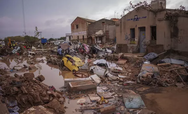 Vehicles trapped after the floods are pictured in an area affected by floods in Catarroja, Spain, Sunday, Nov. 3, 2024. (AP Photo/Manu Fernandez)