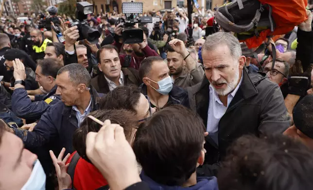 Spain's King Felipe VI, right, speaks with protesters in Paiporta, near Valencia, Spain, A crowd of angry survivors of Spain's floods have tossed mud and shouted insults at Spain's King Felipe VI and government officials when they made their first visit to one of the hardest hit towns. (Ana Escobar/EFE via AP)