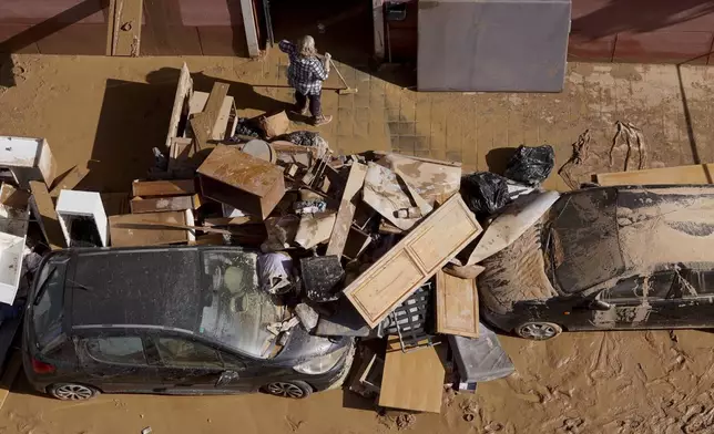 Residents clean their house affected by floods in Valencia, Spain, Thursday, Oct. 31, 2024. (AP Photo/Alberto Saiz)