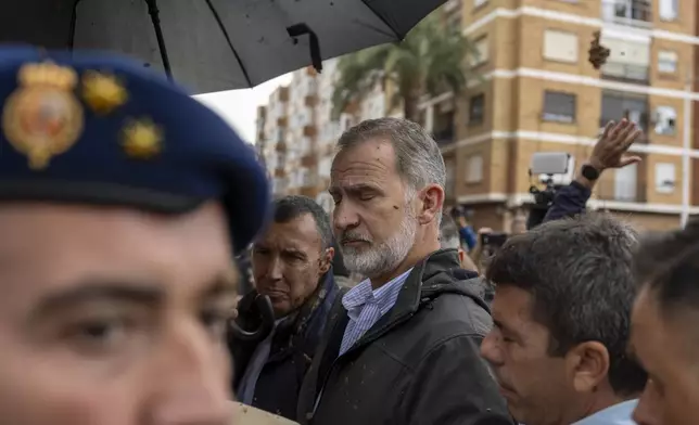 Spain's King Felipe VI, centre, walks amidst angry Spanish flood survivors in Paiporta, near Valencia, Spain, Sunday Nov. 3, 2024. (AP Photo/David Melero)