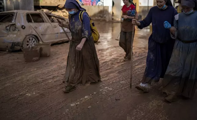 Sister Kelly walks after working as volunteer cleaning houses affected by floods in Paiporta, Valencia, Spain, Tuesday, Nov. 5, 2024. (AP Photo/Emilio Morenatti)