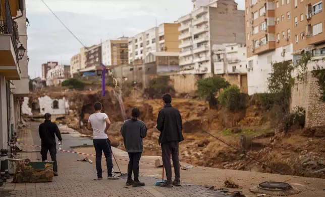 People stand in an area affected by floods in Chiva, Spain, Friday, Nov. 1, 2024. (AP Photo/Manu Fernandez)