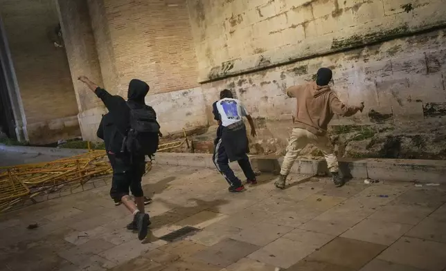 Demonstrators clash with riot police after a peaceful protest organized by social and civic groups, denouncing the handling of recent flooding under the slogan "Mazón, Resign," aimed at the president of the regional government Carlos Mazon, in Valencia, Spain, Saturday, Nov. 9, 2024. (AP Photo/Emilio Morenatti)