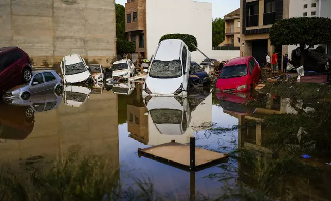 Flooded cars piled up are pictured in Valencia, Spain, Thursday, Oct. 31, 2024. (AP Photo/Manu Fernandez)