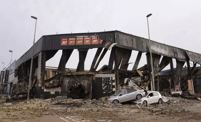 Damaged cars are seen outside a shopping centre after floods in Valencia, Spain, Friday, Nov. 1, 2024. (AP Photo/Alberto Saiz)