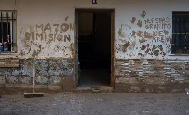 A house affected by flooding is photographed in Massanassa, Valencia, Spain, Friday, Nov. 8, 2024. The graffiti in Spanish means 'Mazon dimisión' in reference to the president of the Valencia community Carlos Mazon. (AP Photo/Emilio Morenatti)