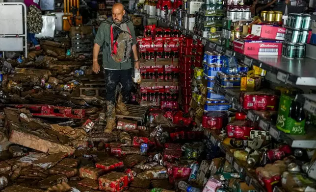 A man walks inside of a supermarket affected by the floods in Valencia, Spain, Thursday, Oct. 31, 2024. (AP Photo/Manu Fernandez)