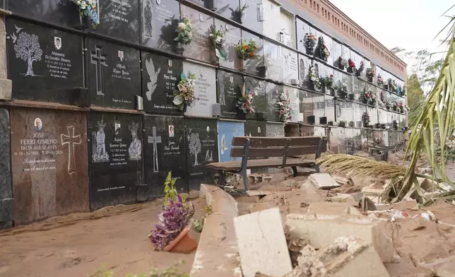 Broken tombstones and debris is seen inside a flood damaged cemetery on the outskirts of Valencia, Spain, Friday, Nov. 1, 2024 after flooding in the region. (AP Photo/Alberto Saiz)