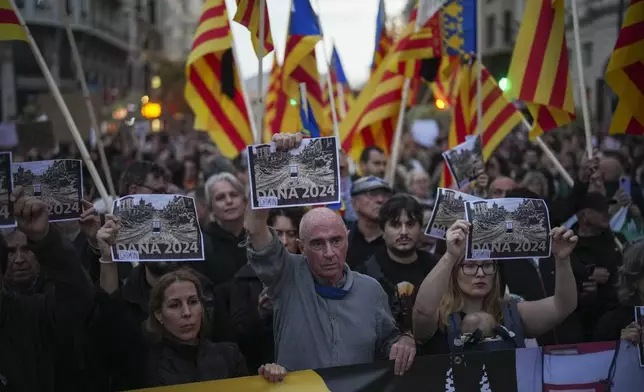 Demonstrators gather for a protest organized by social and civic groups, denouncing the handling of recent flooding under the slogan "Mazón, Resign," aimed at the president of the regional government Carlos Mazon, in Valencia, Spain, Saturday, Nov. 9, 2024. (AP Photo/Emilio Morenatti)