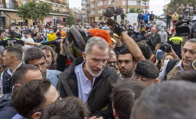 Spain's King Felipe VI speaks with people amidst angry Spanish flood survivors in Paiporta, near Valencia, Spain, Sunday Nov. 3, 2024. (AP Photo/David Melero)