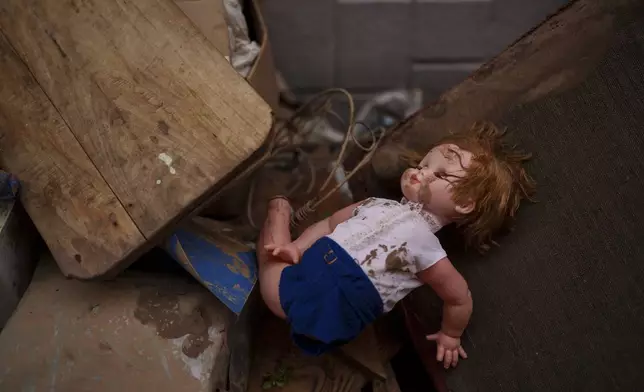 A doll covered in mud is pictured in an area affected by floods, in Algemesi, Spain, Sunday, Nov. 3, 2024. (AP Photo/Manu Fernandez)