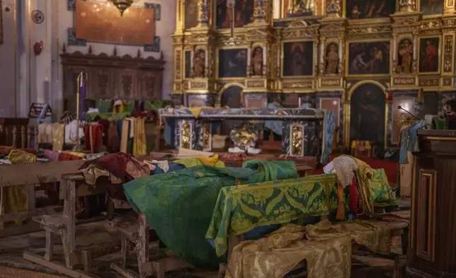 Religious garments are laid out to dry by the altar of the Basilica of Saint James the Apostle, in Algemesi, Spain, Sunday, Nov. 3, 2024. (AP Photo/Manu Fernandez)