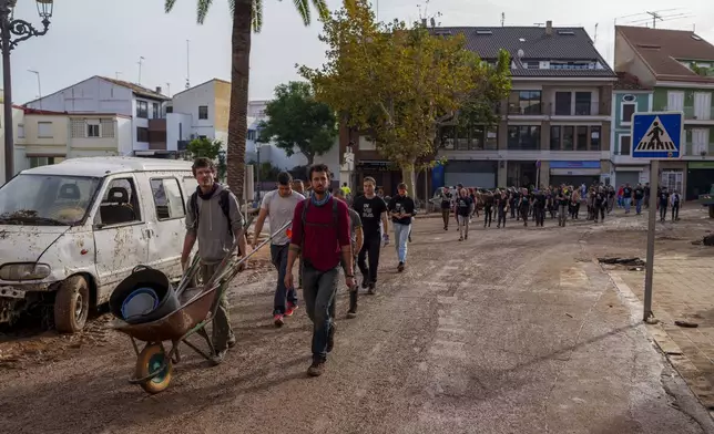 Volunteers arrive to help in an area affected by floods in Chiva, Spain, Friday, Nov. 1, 2024. (AP Photo/Manu Fernandez)