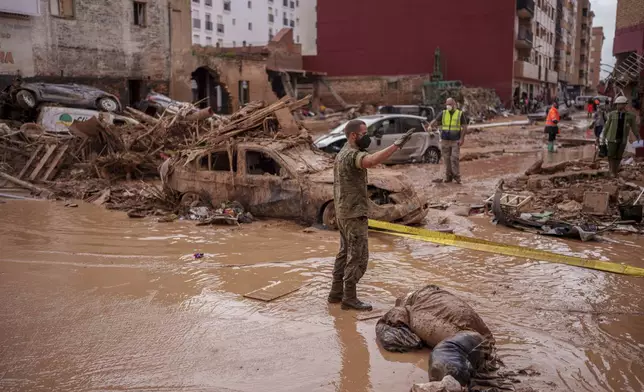 A soldier works in an area affected by floods in Catarroja, Spain, Sunday, Nov. 3, 2024. (AP Photo/Manu Fernandez)