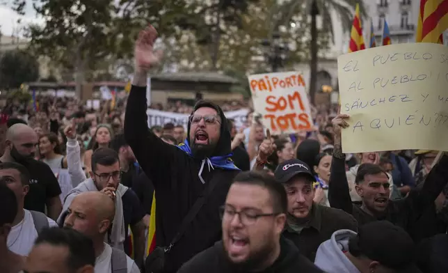 Demonstrators gather for a protest organized by social and civic groups, denouncing the handling of recent flooding under the slogan "Mazón, Resign," aimed at the president of the regional government Carlos Mazon, in Valencia, Spain, Saturday, Nov. 9, 2024. (AP Photo/Emilio Morenatti)