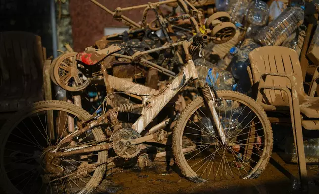 Mud covers a bicycle and various belongings in Valencia, Spain, Thursday, Oct. 31, 2024. (AP Photo/Manu Fernandez)