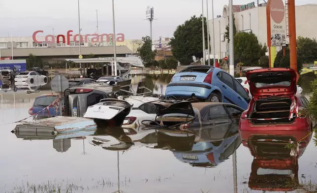 Cars are seen half submerged after floods in Valencia, Spain, Friday, Nov. 1, 2024. (AP Photo/Alberto Saiz)