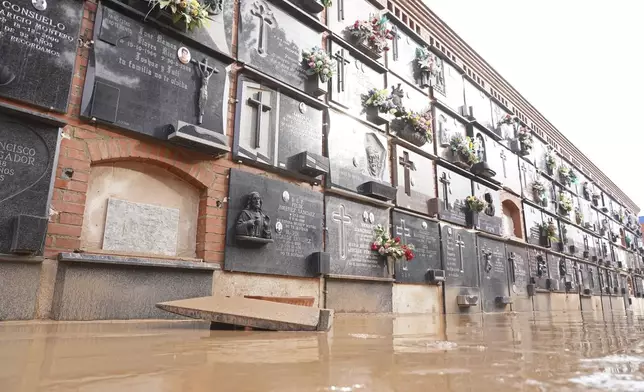 A flooded wall of tombs are seen inside a cemetery on the outskirts of Valencia, Spain, Friday, Nov. 1, 2024 after flooding in the region. (AP Photo/Alberto Saiz)