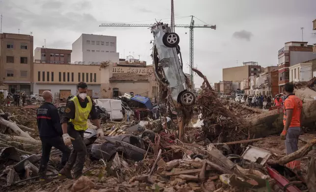 Emergency services remove cars in an area affected by floods in Catarroja, Spain, on Sunday, Nov. 3, 2024. (AP Photo/Manu Fernandez)