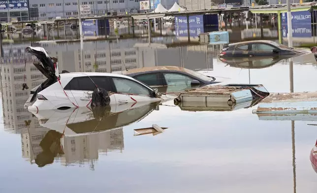 Cars are seen half submerged after floods in Valencia, Spain, Friday, Nov. 1, 2024. (AP Photo/Alberto Saiz)