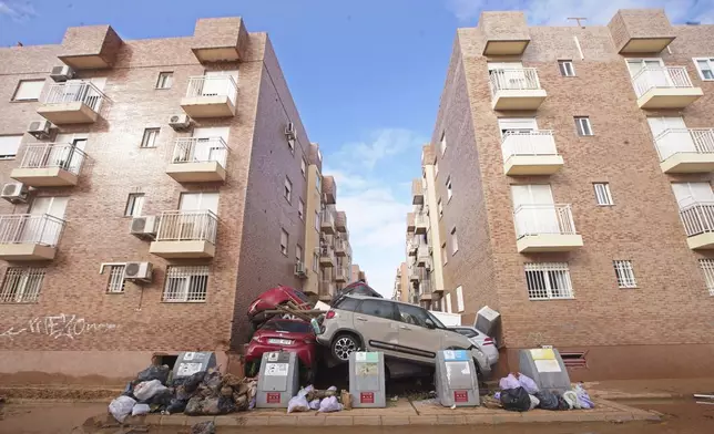 Piled up cars block a street after floods in Massanassa, just outside of Valencia, Spain, Saturday, Nov. 2, 2024. (AP Photo/Alberto Saiz)