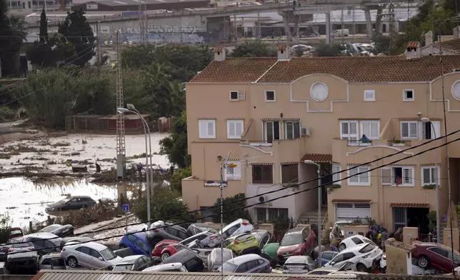 Vehicles are seen piled up after being swept away by floods in Valencia, Spain, Thursday, Oct. 31, 2024. (AP Photo/Alberto Saiz)