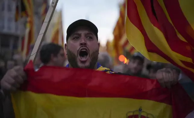 A demonstrator shouts during a protest organized by social and civic groups, denouncing the handling of recent flooding under the slogan "Mazón, Resign," aimed at the president of the regional government Carlos Mazon, in Valencia, Spain, Saturday, Nov. 9, 2024. (AP Photo/Emilio Morenatti)